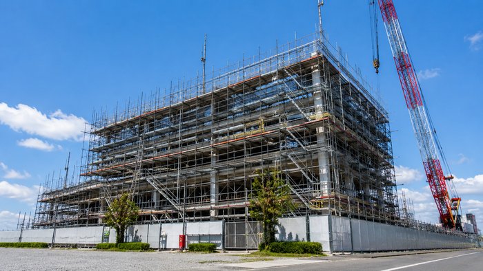足場に囲まれ建設中の建物